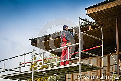 Man standing on scaffolding and restore old wooden house roof structure Stock Photo