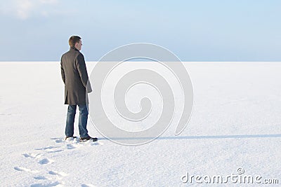 Man standing on the shore of a frozen sea downshifting way relax Stock Photo