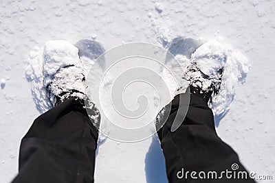 Man standing in the snow, closeup of a foot in a shoe from above. Stock Photo