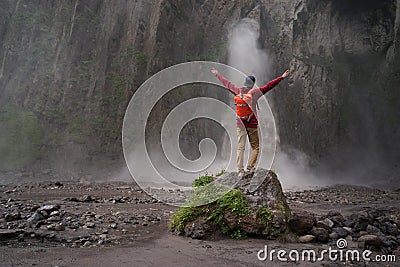 Man standing on stone and looking on waterfall Stock Photo