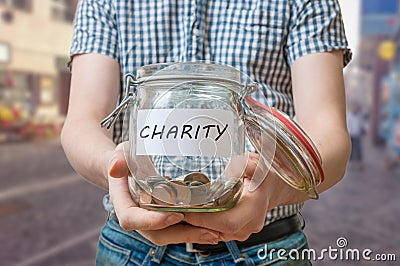 Man standing on street is collecting money for charity and holds jar Stock Photo