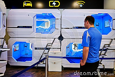 A man stands of a high-tech mini-hotel in the Japan style. Aerosleep modern capsule hotel at airport - Sheremetievo airport, Editorial Stock Photo