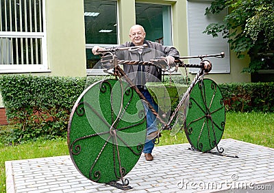 The man stands near a topiarny sculpture Bicycle. Svetlogorsk, Kaliningrad region Editorial Stock Photo