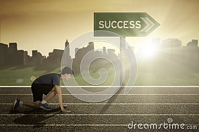 Man in start position with success signpost Stock Photo
