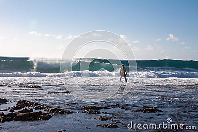 Man stay in the rock beach and look on big waves. Sunny day. Editorial Stock Photo