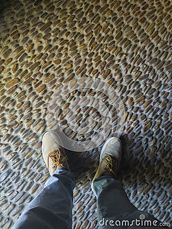 Man stepping on pebbles floor Stock Photo