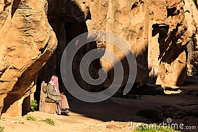 Man stitting in a small passage between the steep rocks at Little Petra in Siq al-Barid, Wadi Musa, Jordan Editorial Stock Photo