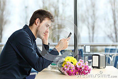 Man stood up in a date checking phone messages Stock Photo