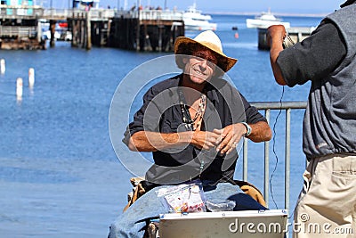 California. USA. October 2012. A man in a straw hat makes beads and sells them Editorial Stock Photo