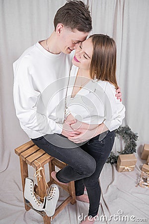 Man stroking pregnant wife& x27;s belly. Happy young couple at Christmas Stock Photo