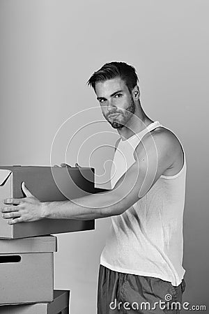 Man with strong arms standing among cardboard boxes Stock Photo