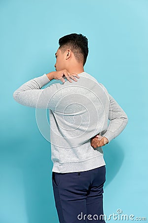 Man student feel shoulder pain with blue background, asian Stock Photo