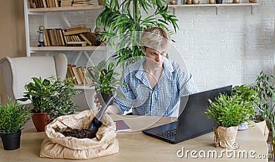 A man studies and takes notes with a laptop studying house plants, performs scientific work exploring botany Stock Photo