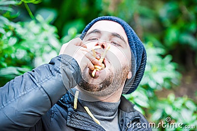 Man stuffing his face with french fries Stock Photo