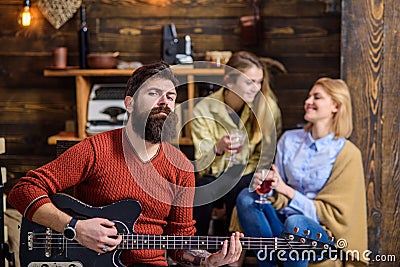 Man with stylish beard enjoying creative process. Musician entertaining his wife and daughter. Girls with smiling face Stock Photo