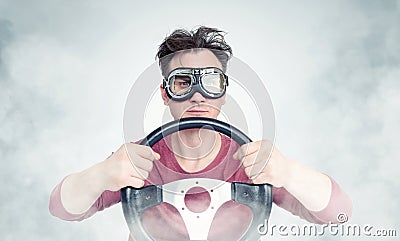 Man in stylish goggles with steering wheel on background, car driver concept Stock Photo