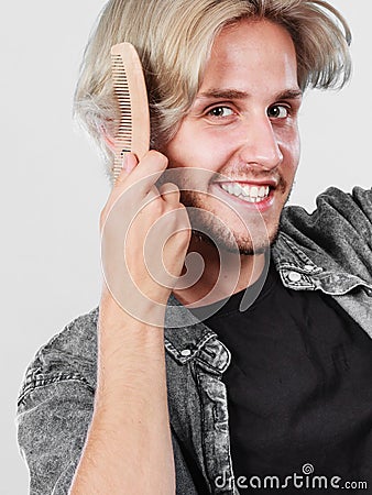 Man with stylish haircut combing his hair Stock Photo