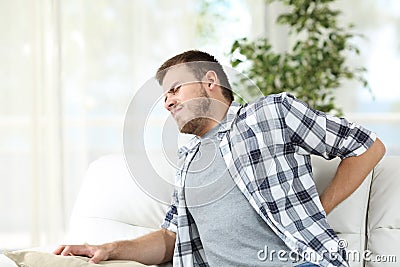 Man suffering back pain at home Stock Photo