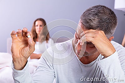 Man Suffering From Erectile Dysfunction Holding Pill In Hand Stock Photo