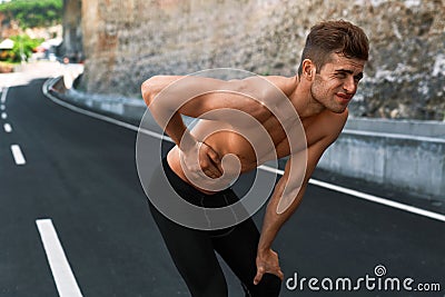 Man Suffering From Stomach Pain After Running Outdoors. Sport Injury Stock Photo