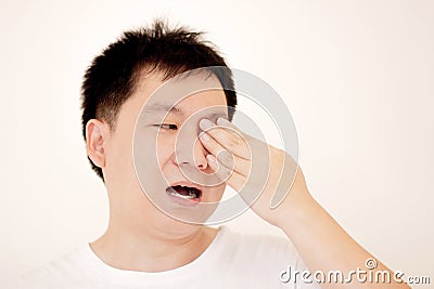 Man suffering from strong eye pain. portrait of young male feeling sick, nose pain and touching painful eyes. Stock Photo