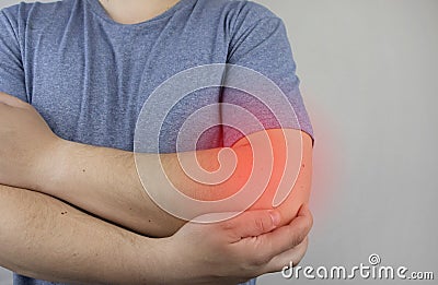 A man suffers from elbow pain. Damaged elbow joint, bone fracture, or sprain. Hand injury and flexion pain concept Stock Photo
