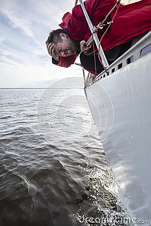 A man suffers from seasickness while walking on a yacht. Stock Photo