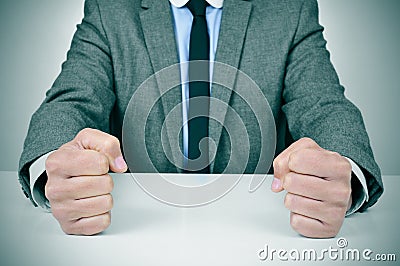 Man in suit banging his fists on a desk Stock Photo