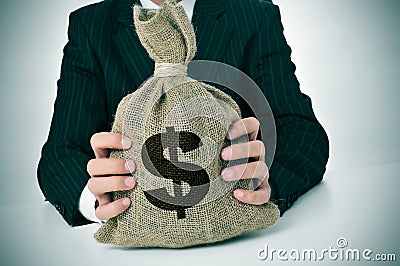 Man in suit with a burlap money bag Stock Photo