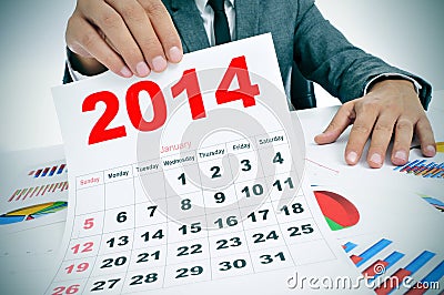 Man in suit with charts and a 2014 calendar Stock Photo