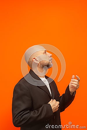 Man in suit jacket, bearded and bald looking up and making gestures Stock Photo