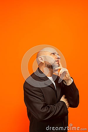 Man in suit jacket, bearded and bald looking up and making gestures Stock Photo