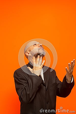 Man in suit jacket, bearded and bald looking up and making gestures Stock Photo