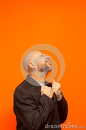 Man in suit jacket, bearded and bald looking up and making gestures Stock Photo