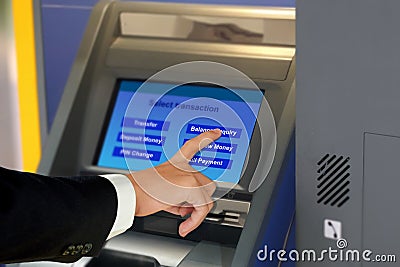 Man in suit touching display screen at ATM terminal Stock Photo