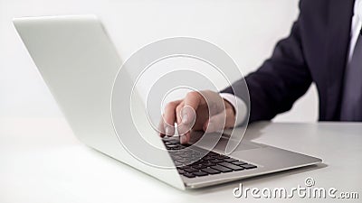 Man in suit typing on laptop in office, pushing spacebar, online working concept Stock Photo