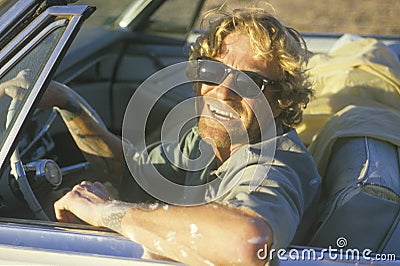 A man with sunglasses driving a Cadillac convertible Editorial Stock Photo