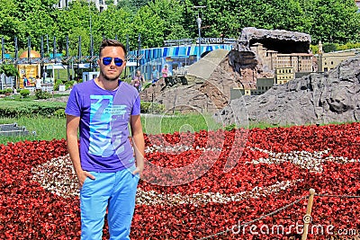 Man in sunglasses standing near the flowers turkish flag in the city park Editorial Stock Photo