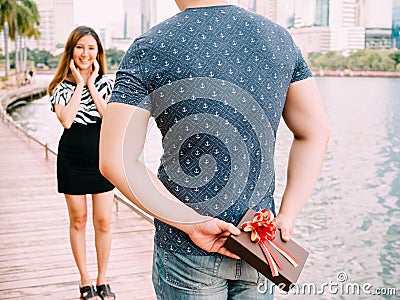 Man surprises his girlfriend by giving out a gift - love and relationship concept Stock Photo