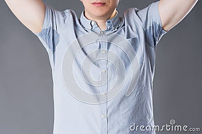 Man with sweaty armpits on gray background Stock Photo