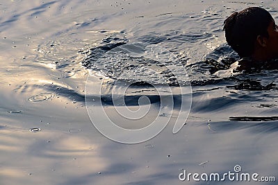 Man swim's inside Yamuna river in Delhi India during morning time, Swimming inside Yamuna River Stock Photo