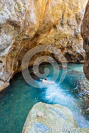 man swimming in a beautiful natural turquoise pool in a rocky cave in the province of Puntarenas in Costa Rica Editorial Stock Photo