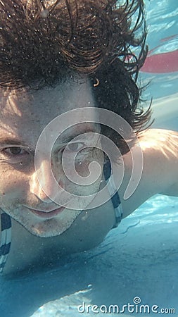 Man in swimming pool underwater. Male diving from closeup portrait front view. Stock Photo