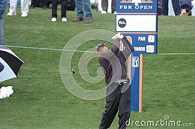 Man swinging a golf club in front of a crowd of spectators in Denver Editorial Stock Photo