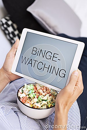 Man and tablet, with the text binge-watching in it Stock Photo