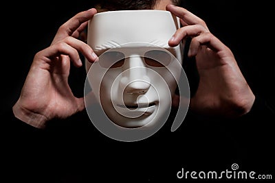 The man takes off the white mask from his face Stock Photo
