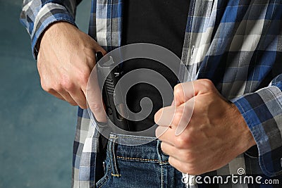 Man takes out a gun from jeans, close up Stock Photo