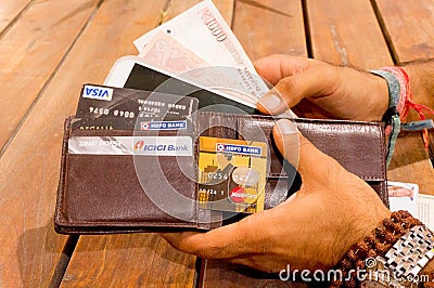 Man taking indian payment options out of a wallet Editorial Stock Photo