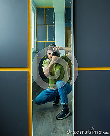 Man taking a picture, young man taking a photo, a man with camera, reflection of man in mirror Stock Photo