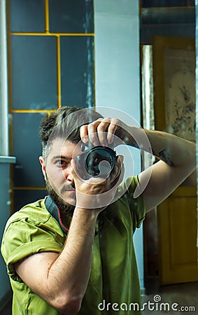 Man taking a picture, young man taking a photo, a man with camera, reflection of man in mirror Stock Photo